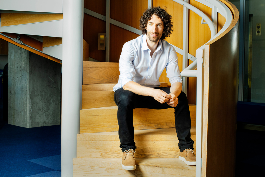 Guy Bresler sits on the bottom step of a spiral staircase.